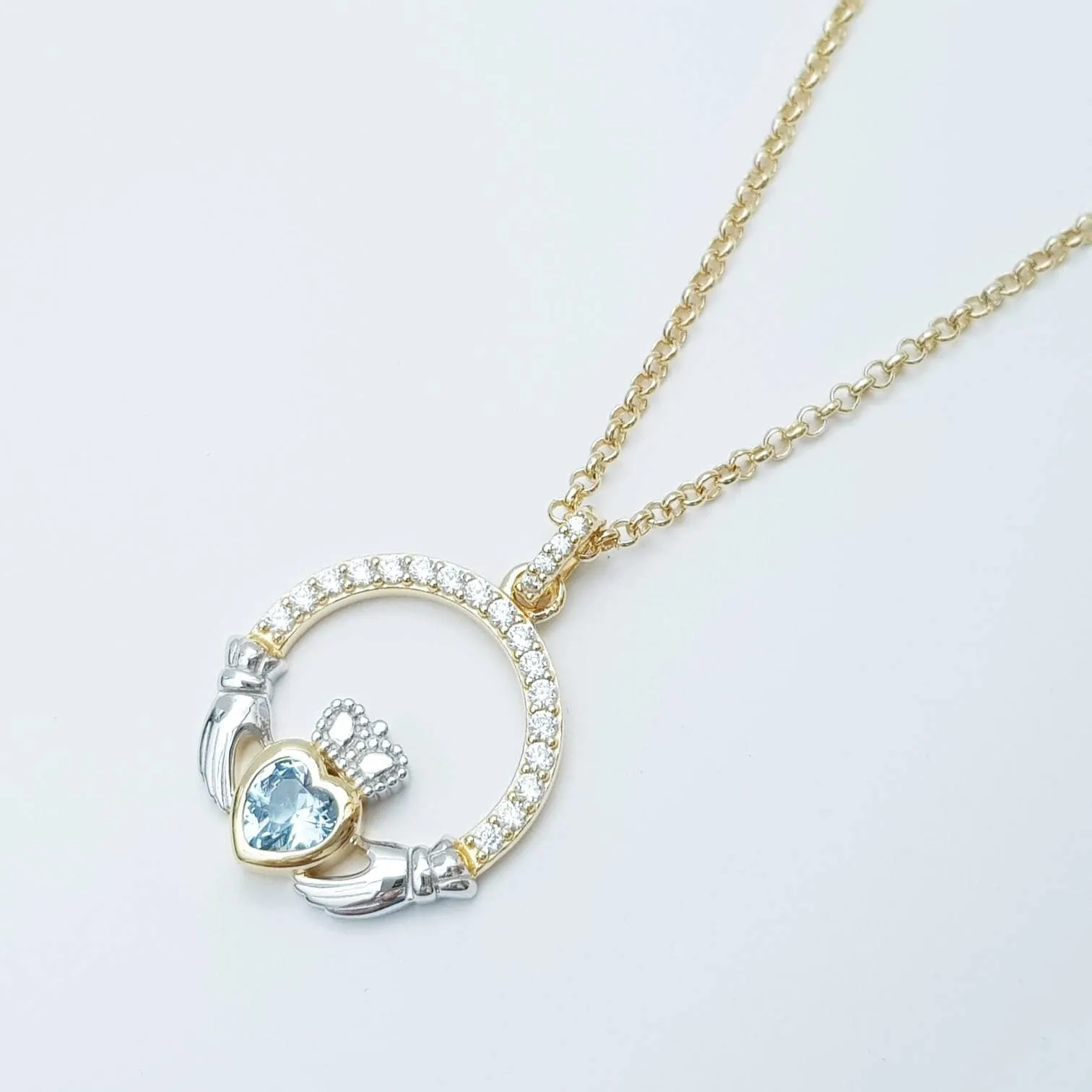 Silver and gold claddagh pendant with Aquamarine blue stone