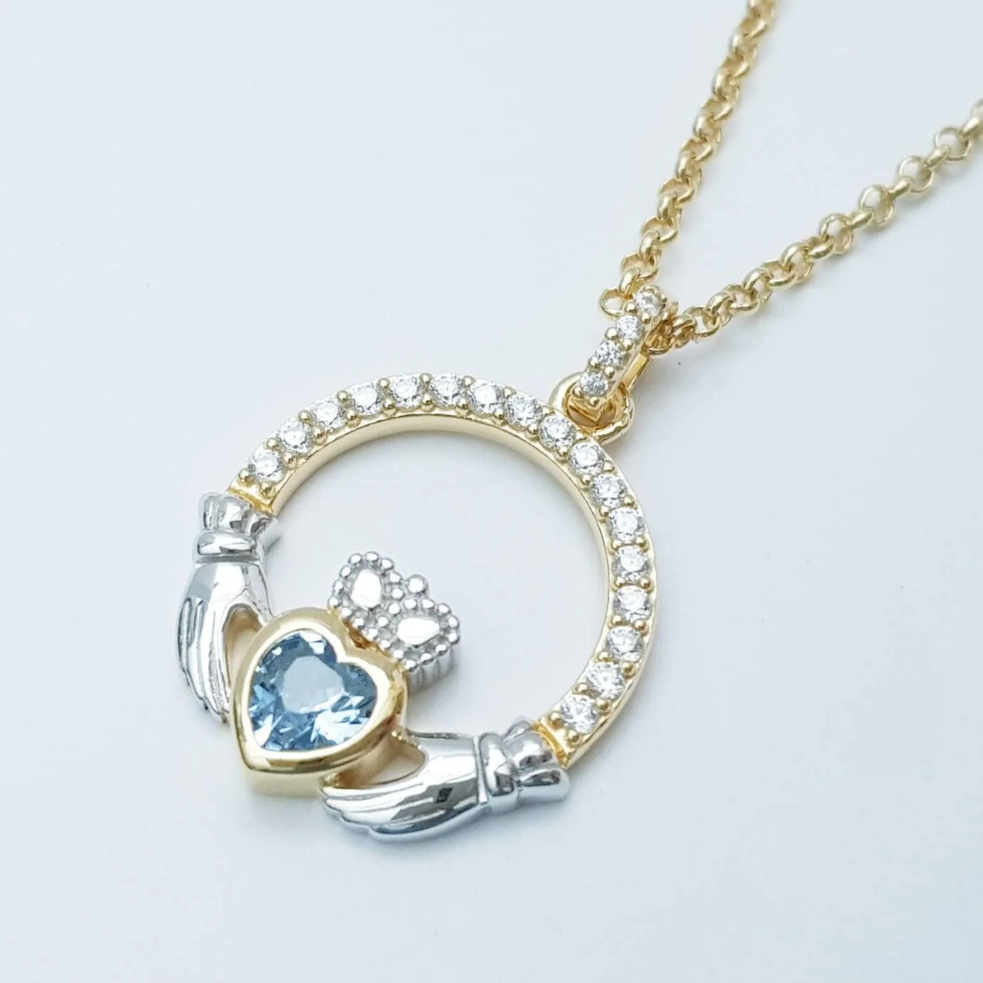 Silver and gold claddagh pendant with Aquamarine blue stone